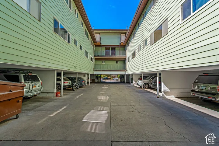 Covered parking area with concrete flooring, supported by structural columns