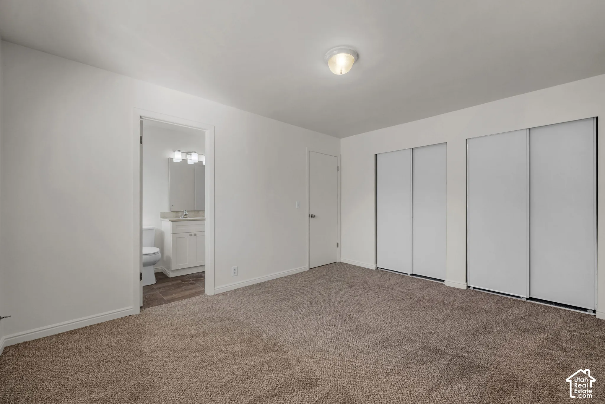 Spacious room with plush carpeting, neutral wall finishes, and ceiling-mounted lighting