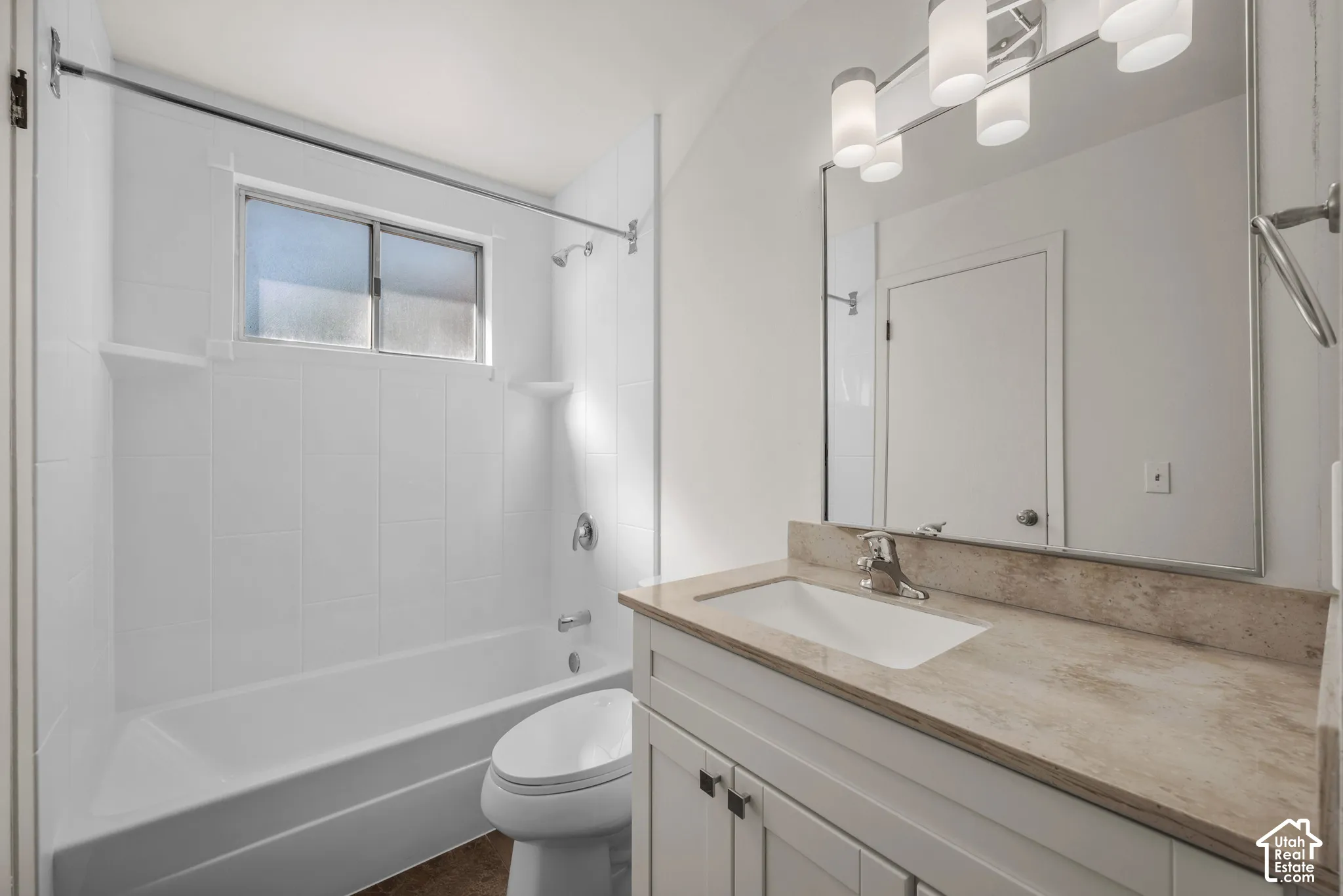 Vanity with an integrated rectangular sink, light-toned countertop, and chrome faucet
