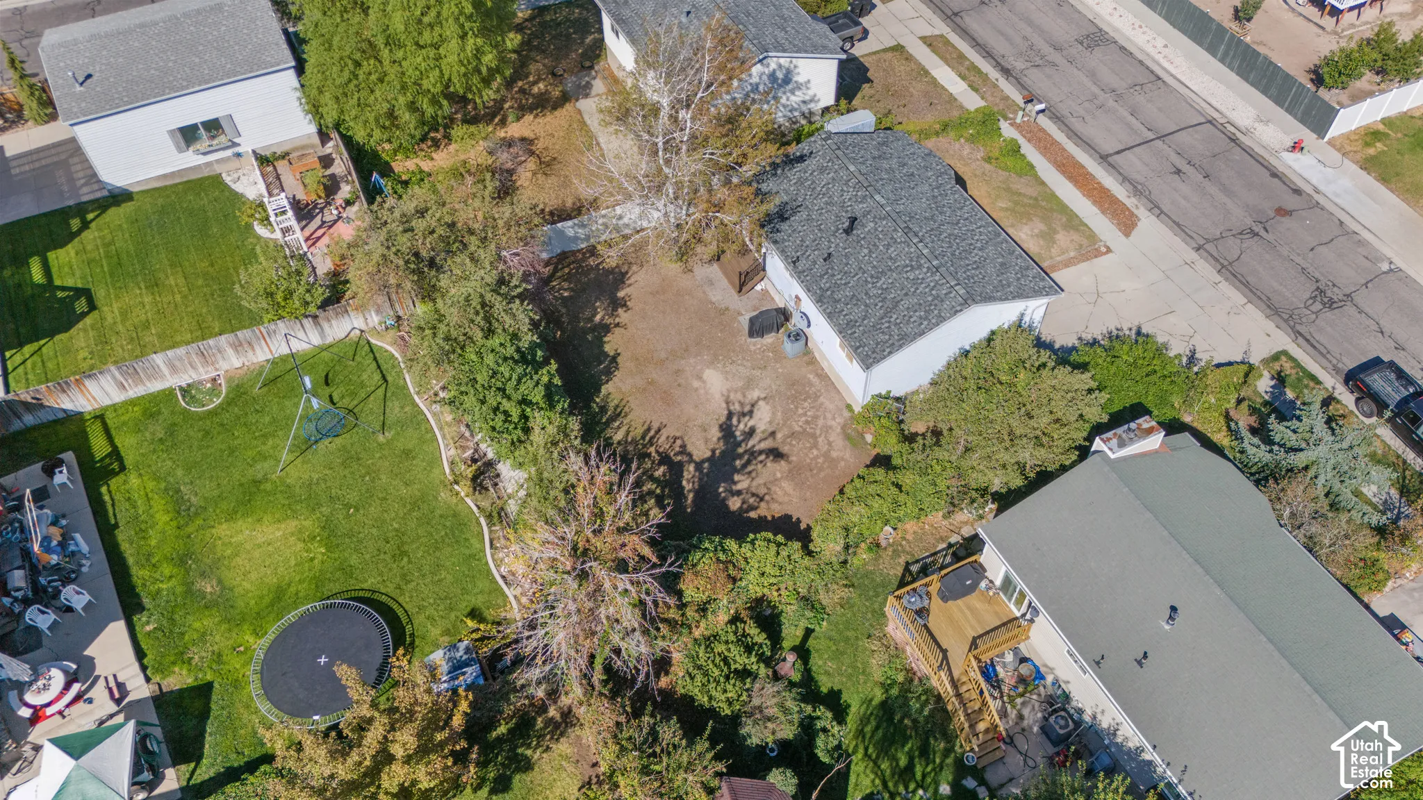 Residential property featuring a shingle roof and a paved driveway