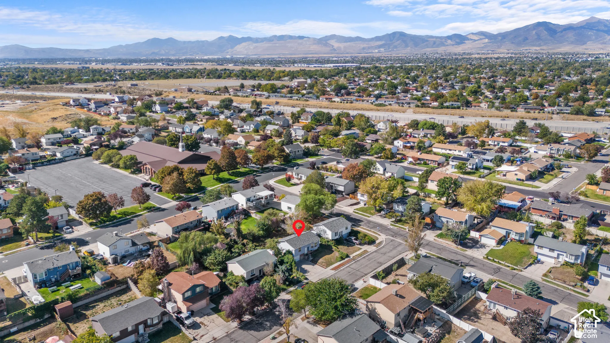 Residential neighborhood setting with mature trees and visible mountain range