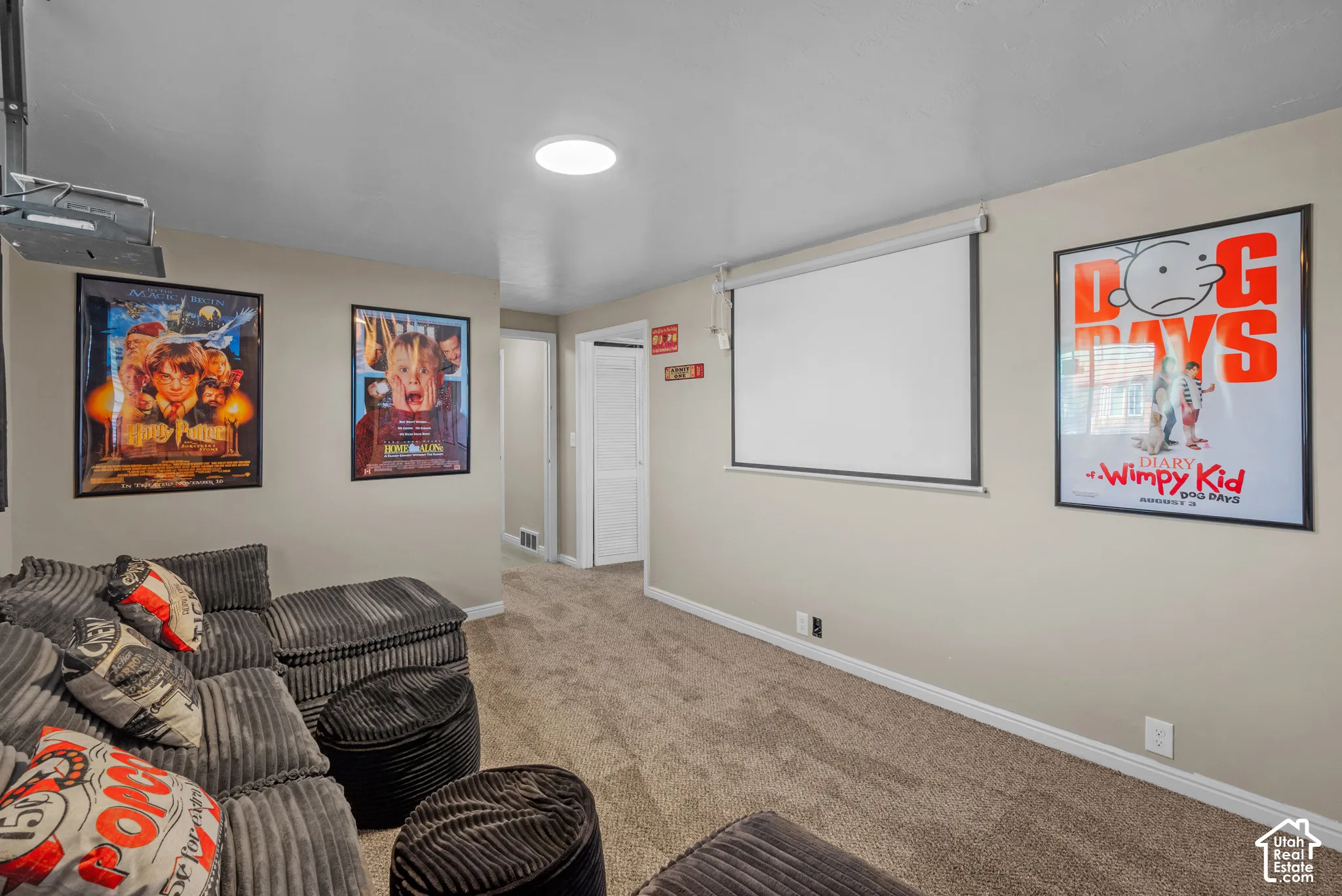 Dedicated media space featuring a drop-down projection screen and recessed ceiling lighting