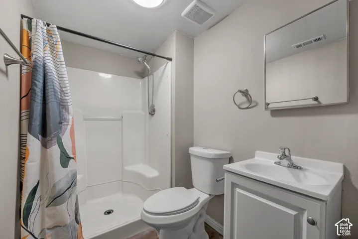 White single vanity with integrated sink, chrome faucet, and mirrored medicine cabinet