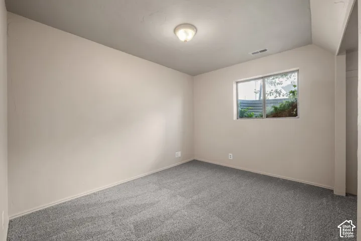 Plush gray carpeting, neutral wall finishes, recessed window, and flush mount lighting