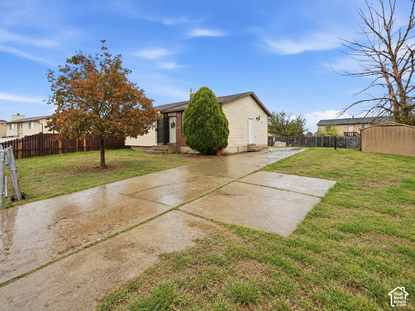 Single-story exterior with light-colored siding, a concrete driveway, and a front entry