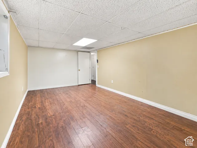 Wood-finish flooring with light beige walls and a white acoustical tile ceiling
