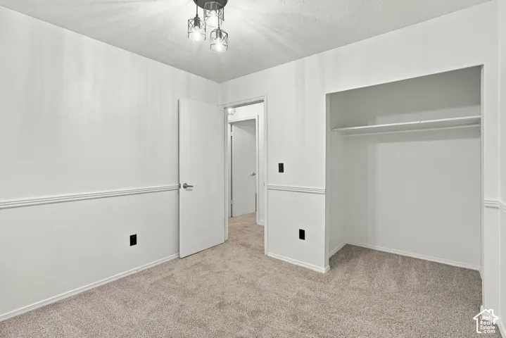 Bedroom 2 featuring new paint, carpet, and modern lighting.