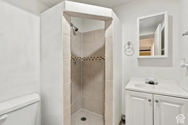 Angled shower stall with tile surround and decorative mosaic accent band