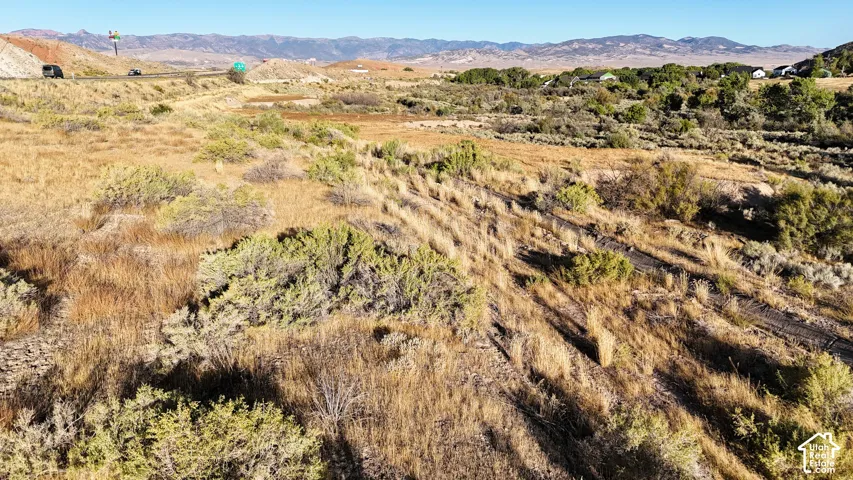 Expansive natural landscape with varied terrain and distant mountains under a clear sky