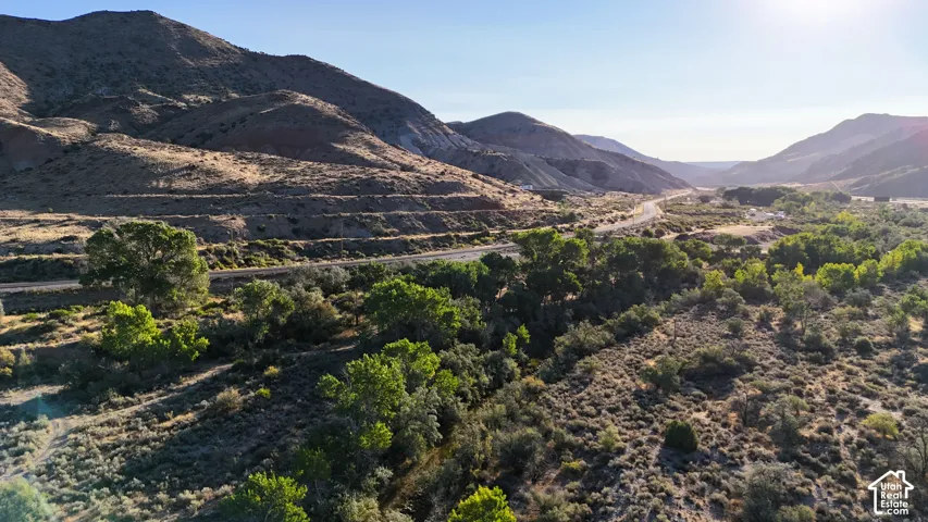 Expansive mountainous terrain featuring a winding road and abundant natural vegetation