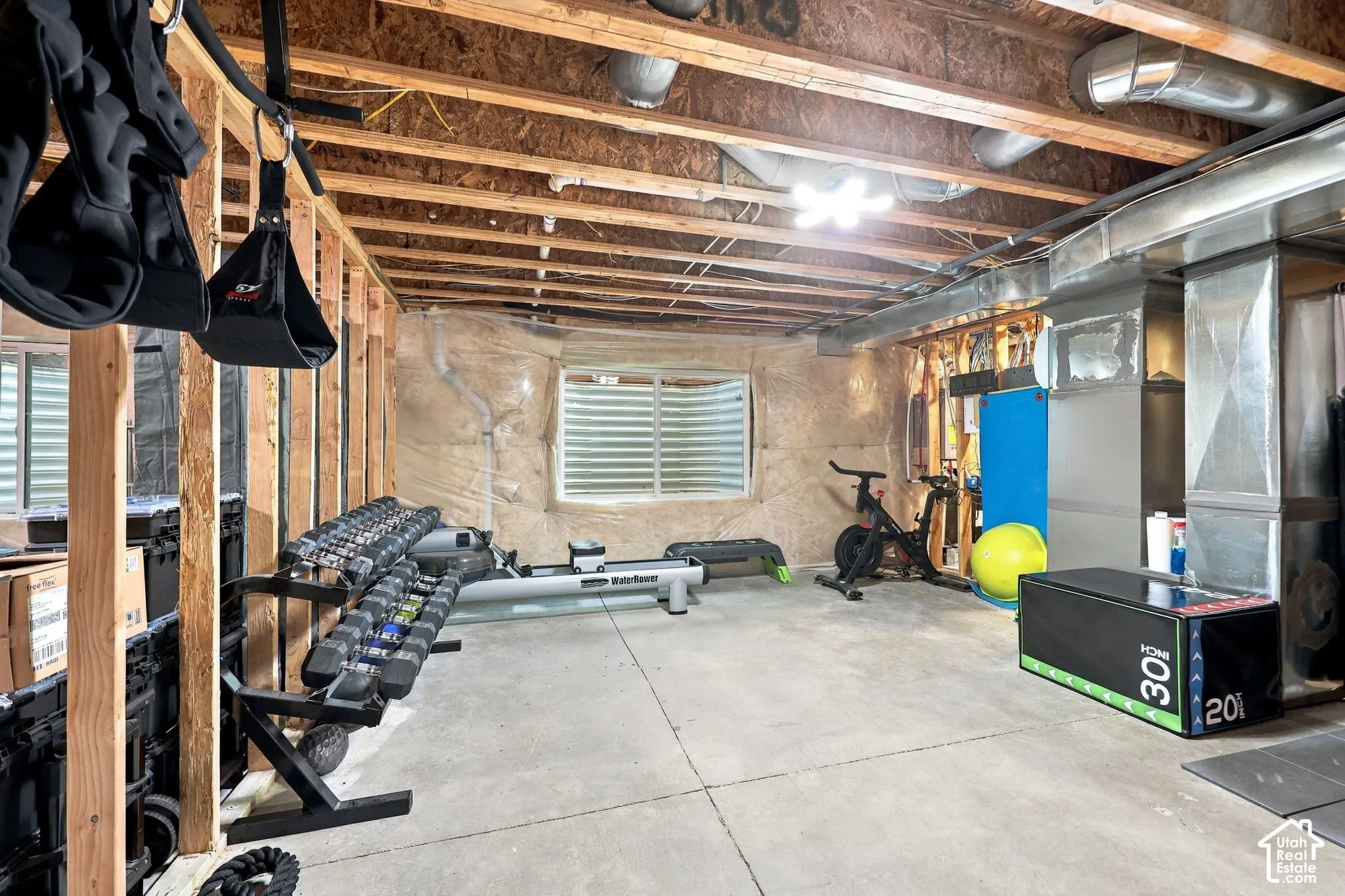 Exposed ceiling joists, concrete flooring, and an egress window