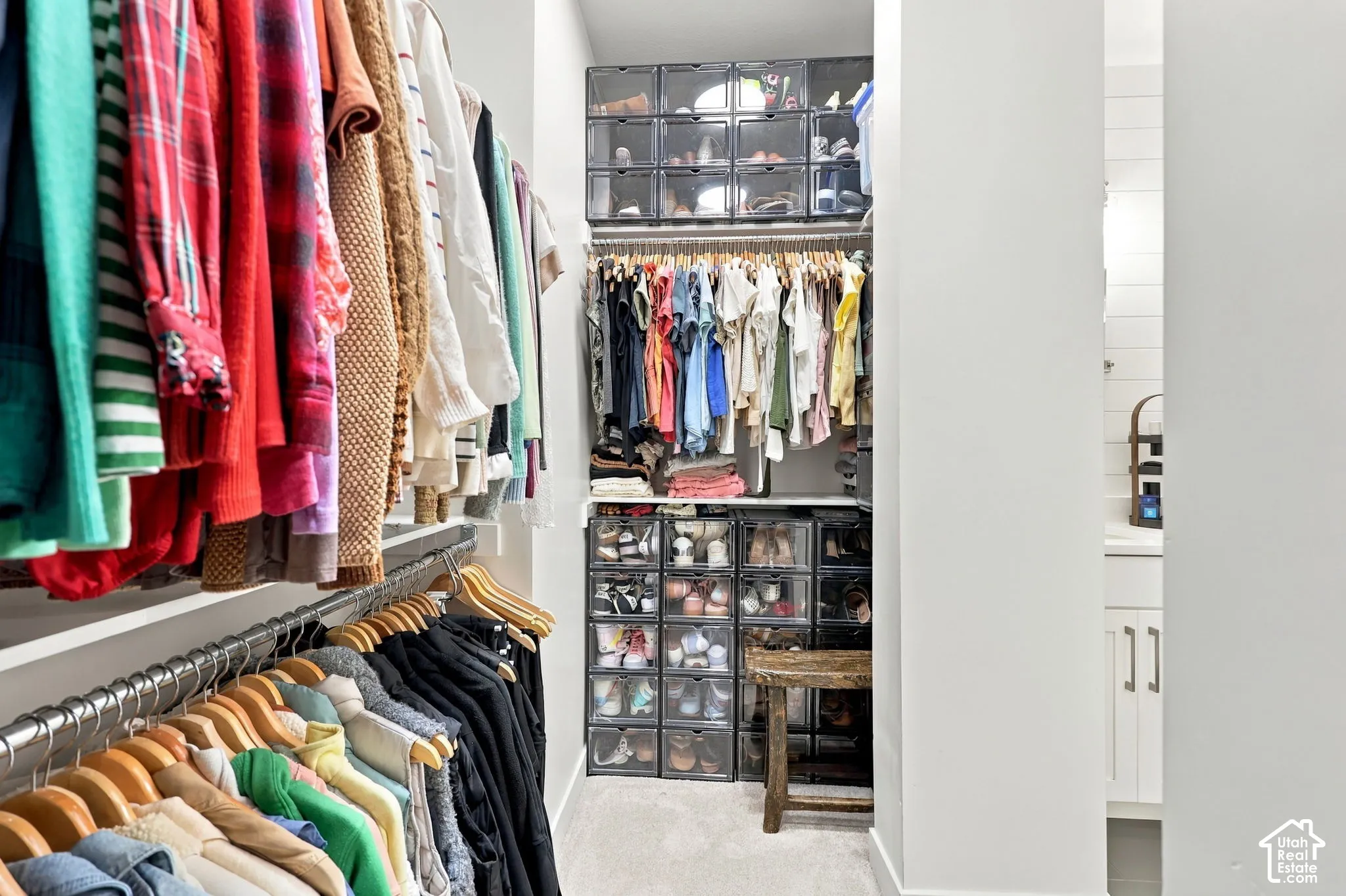 Organized closet with wall-mounted clothing rods and recessed lighting