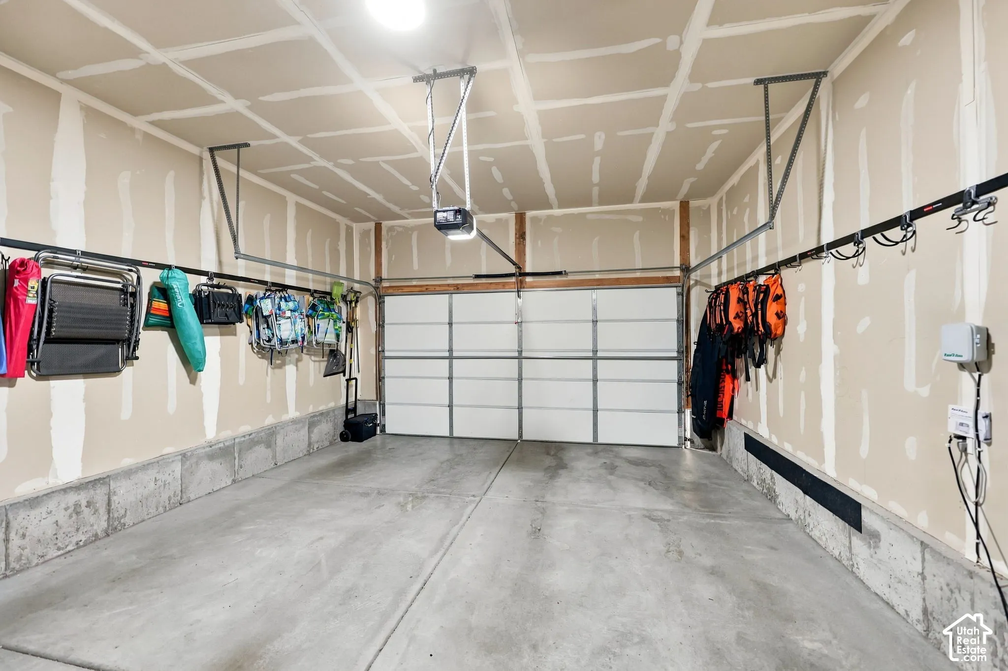 Attached garage with concrete flooring, automatic garage door opener, and overhead lighting