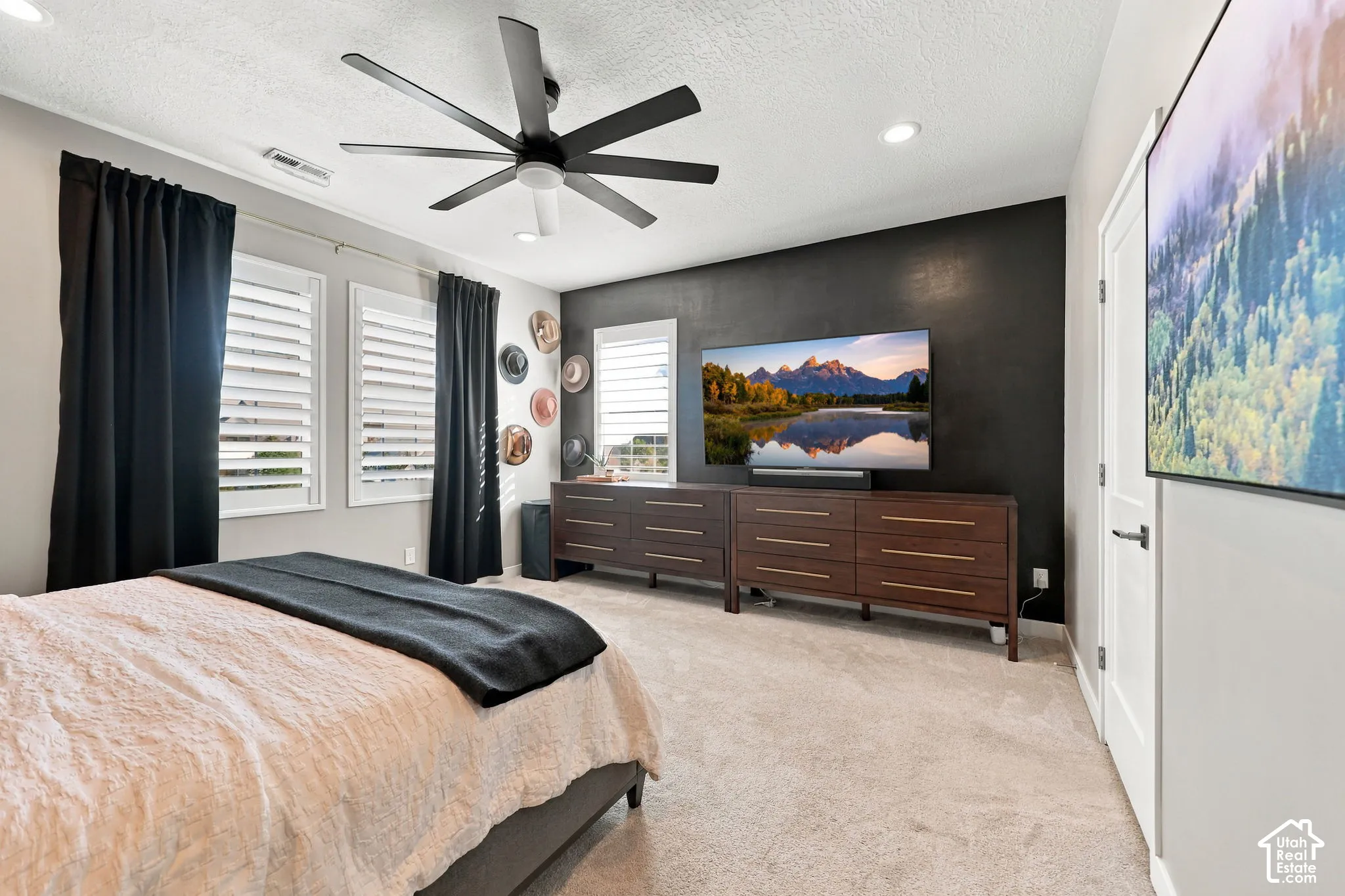 Recessed lighting, wood-finish dressers, and a ceiling fan with multiple blades