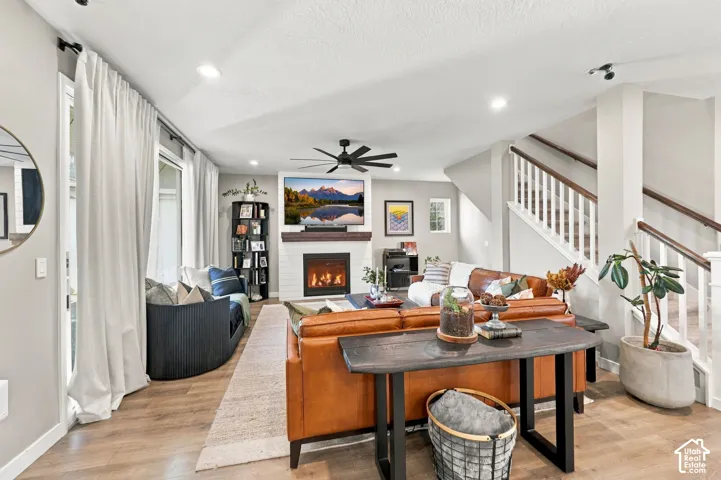 Living area with wood-finish flooring, recessed lighting, and a white shiplap fireplace with a wood mantle