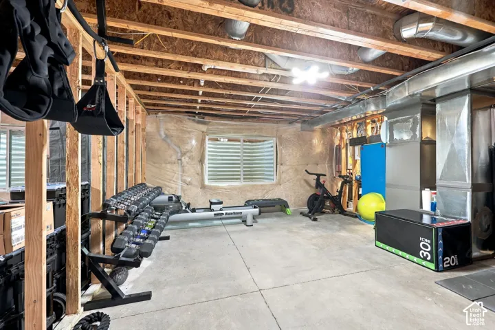 Exposed ceiling joists, concrete flooring, and an egress window
