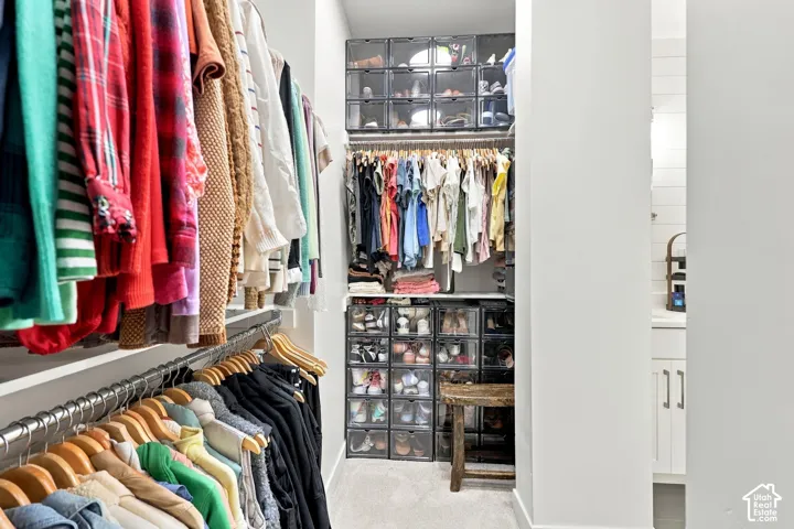 Organized closet with wall-mounted clothing rods and recessed lighting