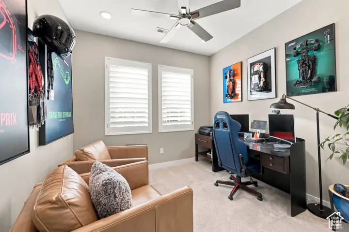 Recessed lighting, ceiling fan, two windows with plantation shutters, light-toned carpeting, and neutral wall paint