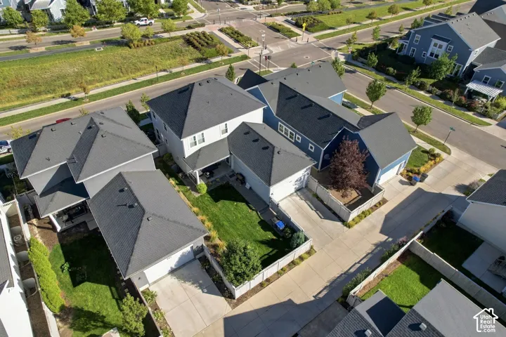 Multiple residential structures with dark shingle roofs, light-colored siding, and attached garages