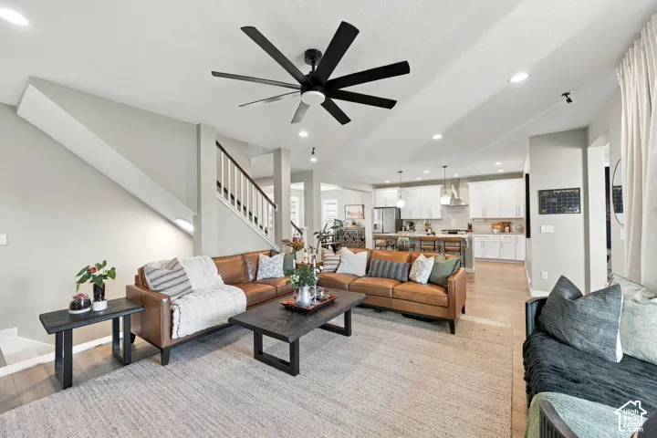 Open-concept living space with light-tone flooring, recessed lighting, and a contemporary ceiling fan