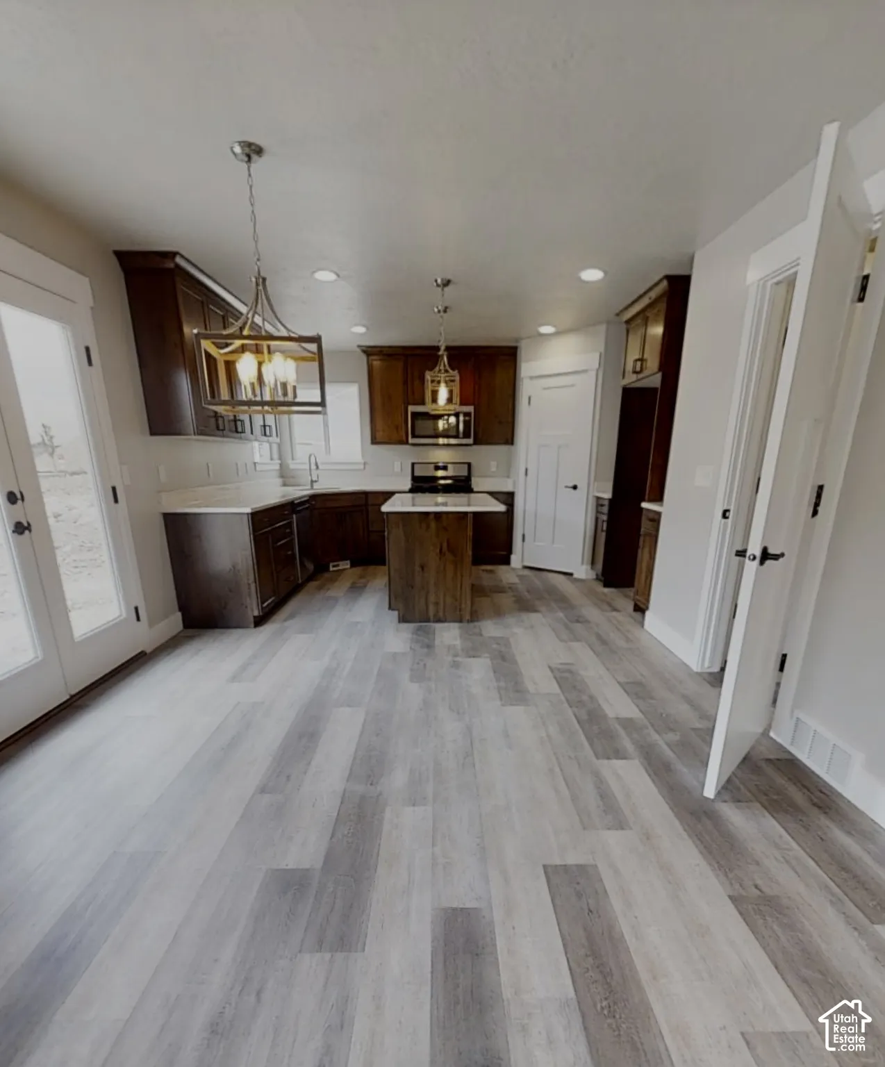 Kitchen featuring a central island, wood-finish flooring, dark wood cabinetry, and recessed lighting