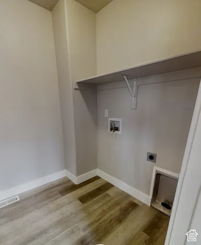 Wood-finish flooring, integrated utility connections, and an overhead shelf