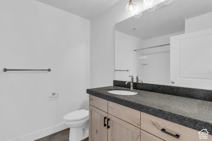 Full secondary bath with extended vanity, stained wood cabinets and granite slab countertops.