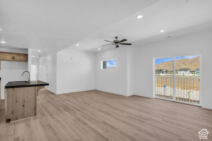 Family room adjacent to kitchen with sliding glass door to balcony and ceiling fan.