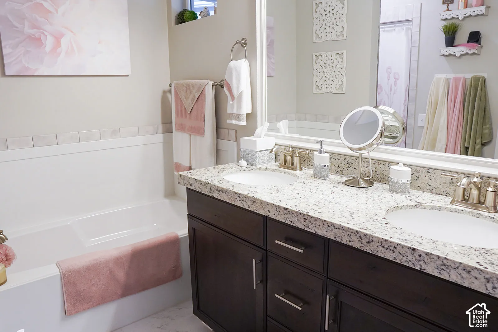Dual vanity with undermount sinks, speckled countertop, and dark wood-finish cabinetry