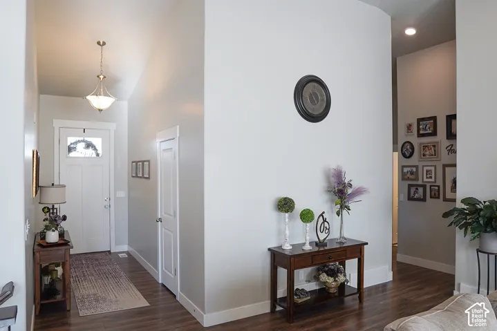 Wood-finish flooring throughout, bright white walls, recessed ceiling lighting, and a front entry door with an upper glass panel