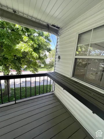 Covered porch with composite decking, black metal railings, and an integrated counter surface