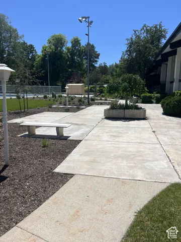 Concrete pathways with a stone bench and elevated planters