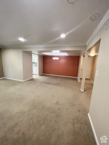 Recessed lighting, crown molding, neutral wall colors, contrasting accent wall, and carpet flooring