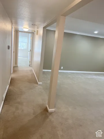 Carpeted flooring throughout, recessed lighting, and crown molding details