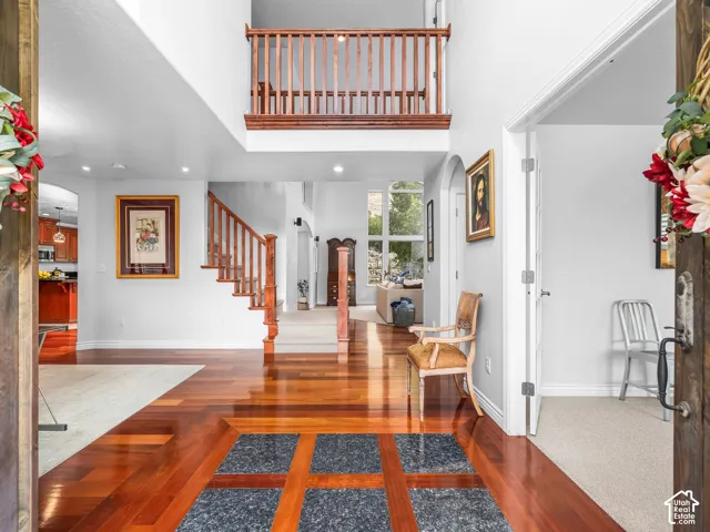 Two-story foyer with rich wood-finish flooring and an inset stone tile pattern