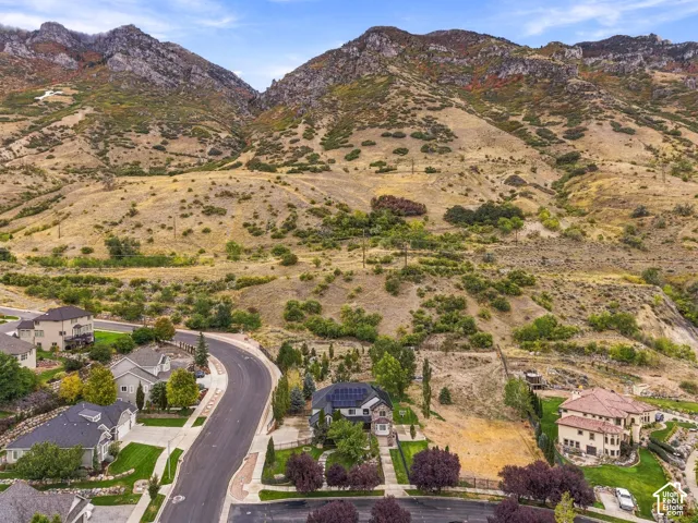 Mountainous terrain backdrop with residential properties and paved roadways