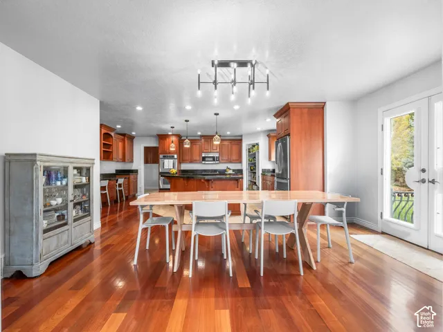 Hardwood-finish flooring, recessed lighting, double French doors, kitchen with wood cabinetry, and stainless steel appliances