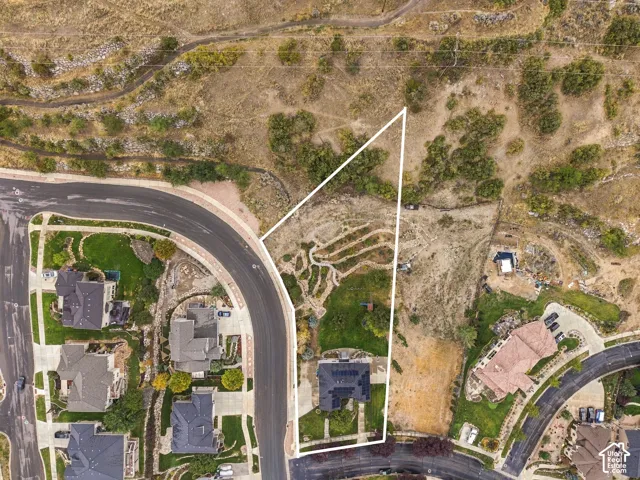 Aerial perspective showcasing an established residential neighborhood, curved streets, and natural landscape