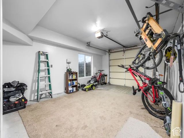 Garage featuring a paneled overhead door, overhead lighting, and an exterior window