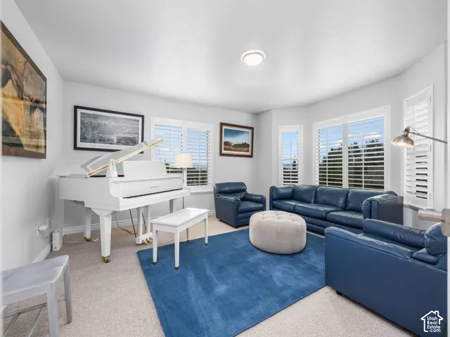 Recessed lighting, bay windows with plantation shutters, light-colored carpeting, and painted walls
