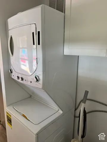 Stacked washer and dryer unit with white cabinetry