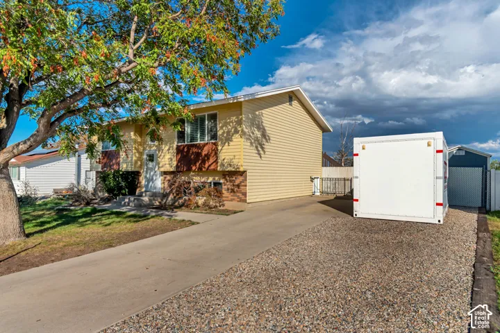 Extended concrete driveway, and a gravel parking with a separate basement entry.