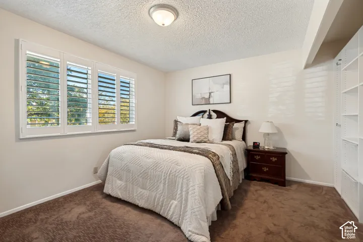 Master Bedroom featuring white plantation shutters, neutral tone walls, and built-in shelving