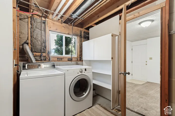 Laundry with functional utility space with built-in cabinetry and open shelving.