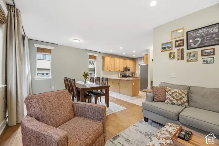 Open-concept living space featuring wood-finish flooring, recessed lighting, and light-toned walls