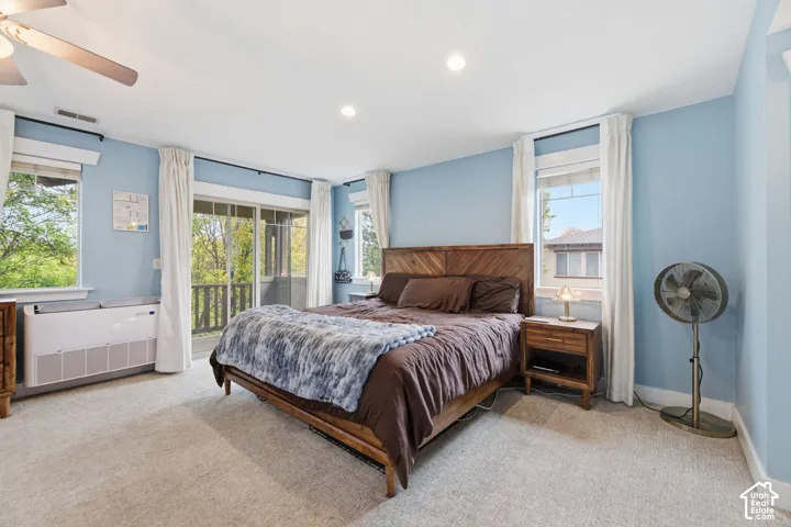 Wall-to-wall carpeting and a ceiling fan with integrated lighting