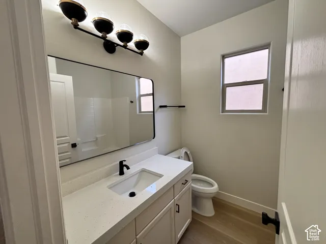 White vanity with a solid surface countertop, matte black faucet, and undermount sink