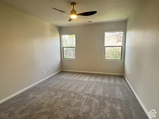 Recessed lighting, ceiling fan with integrated light, two windows, carpet flooring, and light-toned walls