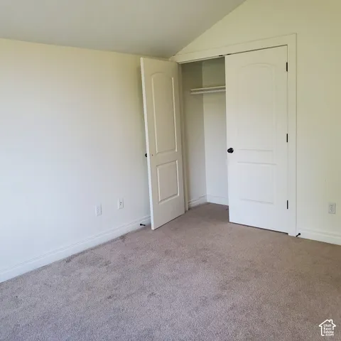 Bedroom featuring a neutral carpet and a closet with bi-fold doors