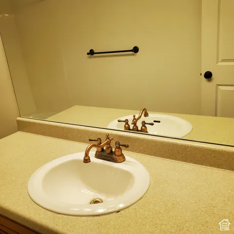 White oval sink with bronze-finish faucet, set in a light speckled countertop